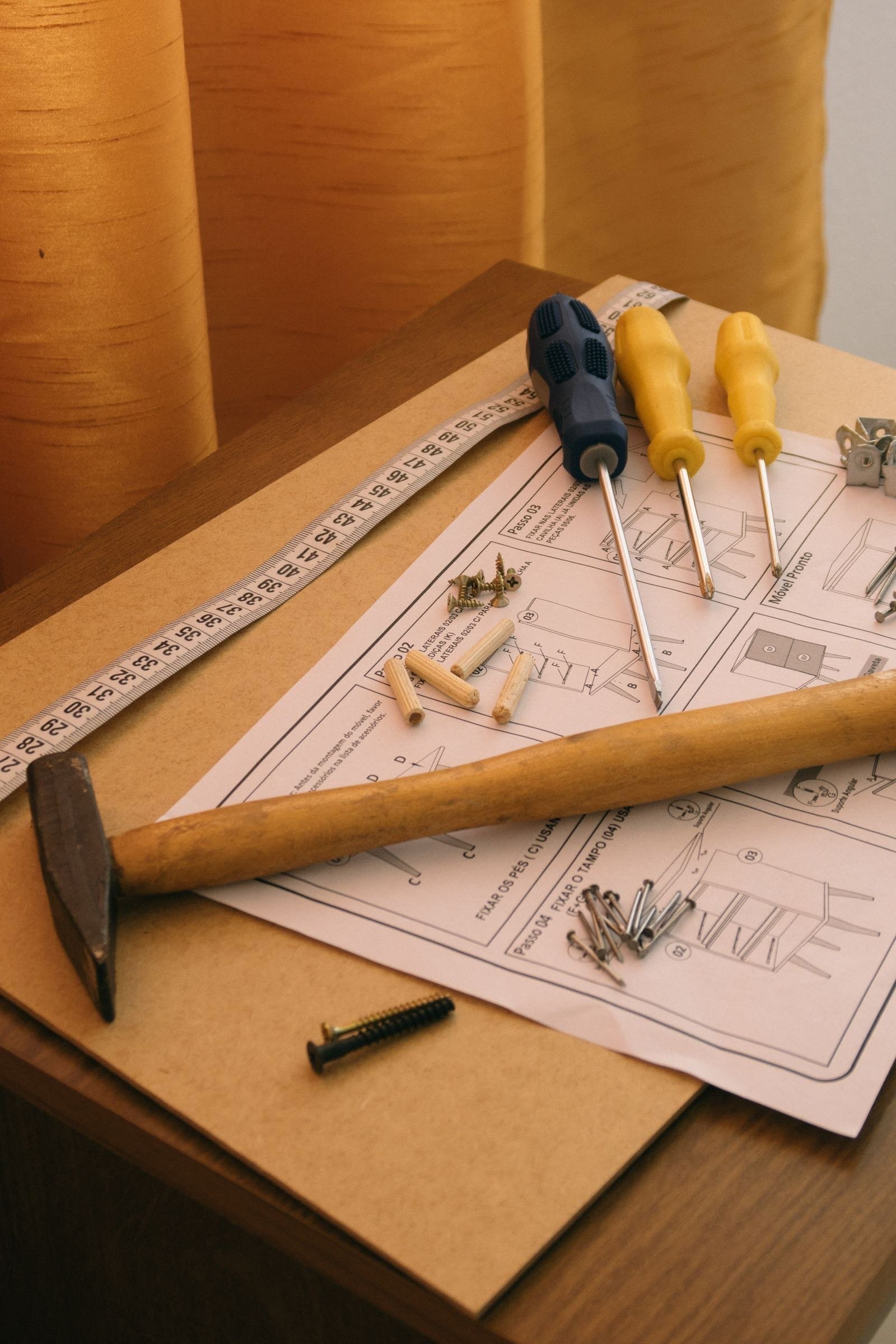 Hammer, screwdrivers and assembly instructions on a wooden board