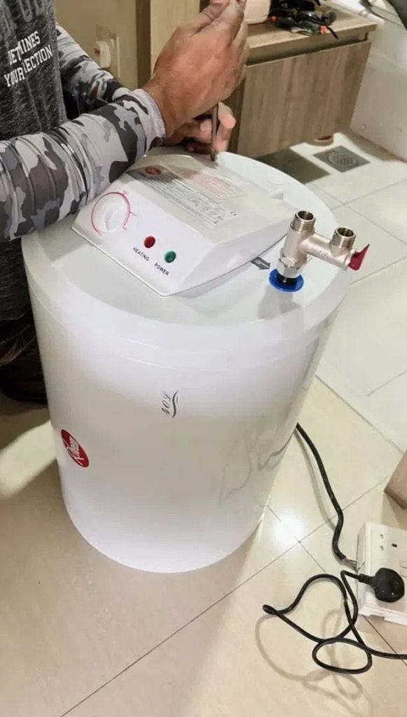 Water heater being fitted, with the control panel and pressure valve visible